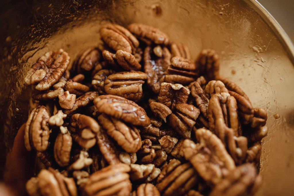 a brown glass bowl of sticky pecans