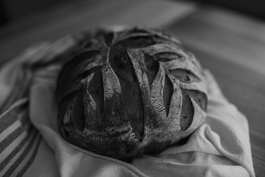 leaf scored sourdough bread on farmhouse towel
