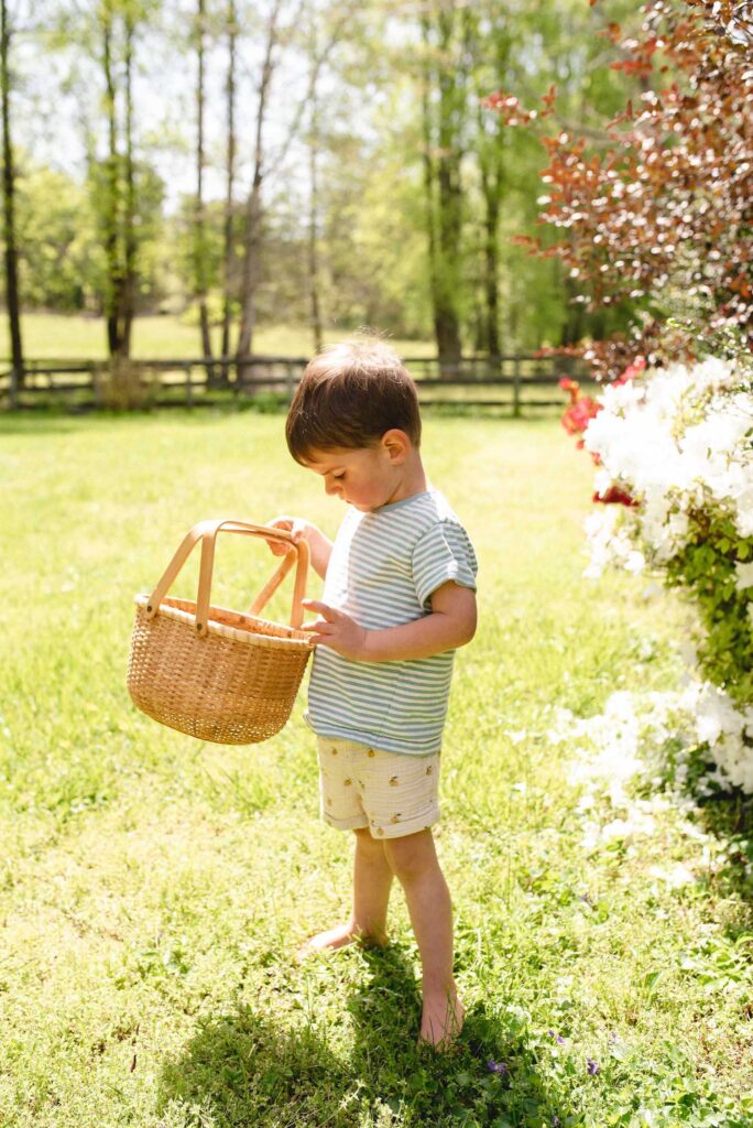 a little boy with a woven basket looking at the inside of the basket