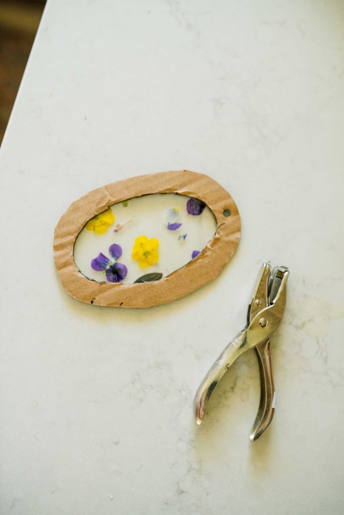a suncatcher oval on a marble counter with a hole punch