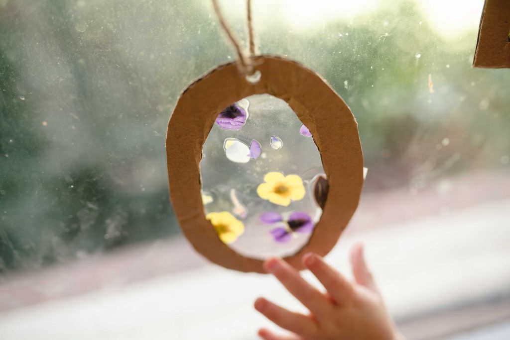 an oval sun catcher with a child's hand reaching up to it